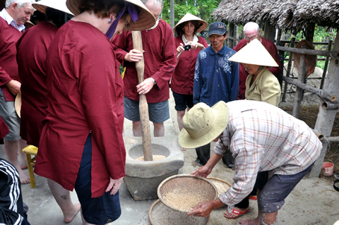 Dạy khách giã gạo bằng tay