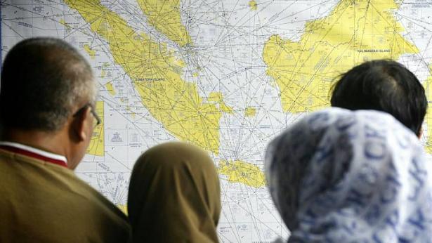 Th&acirc;n nh&acirc;n nạn nh&acirc;n t&igrave;m tr&ecirc;n bản đồ v&ugrave;ng t&igrave;m kiếm m&aacute;y bay v&agrave; h&agrave;nh kh&aacute;ch bị nạn. Ảnh: Straitstimes