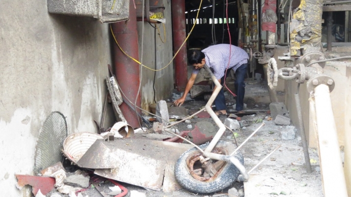 Gia đình chủ xưởng dọn dẹp đống đổ nát