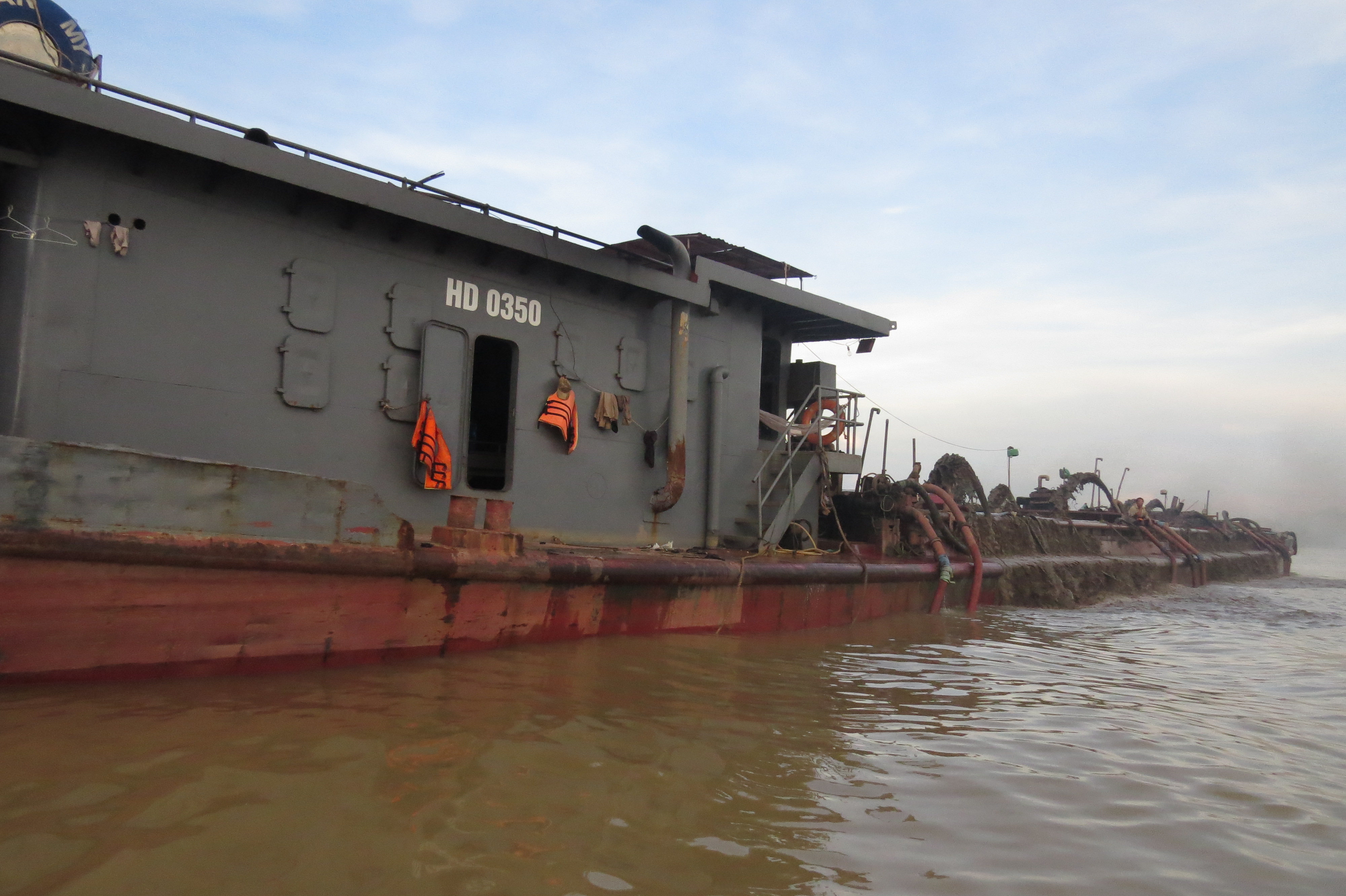 T&agrave;u c&aacute;t tặc đang ngang nhi&ecirc;n h&uacute;t c&aacute;t tại cửa s&ocirc;ng 