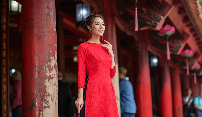 Áo dài đỏ với hoa thêu thủ công nổi bật, tà xếp ly