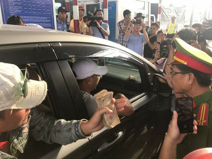 T&agrave;i xế d&ugrave;ng tiền lẻ qua trạm thu ph&iacute; Cai Lậy