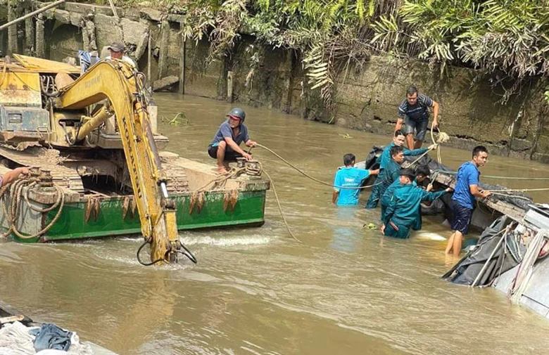 Ng&agrave;nh chức năng c&ugrave;ng người d&acirc;n hỗ trợ trục vớt phương tiện v&agrave; số gạo bị ch&igrave;m l&ecirc;n bờ.