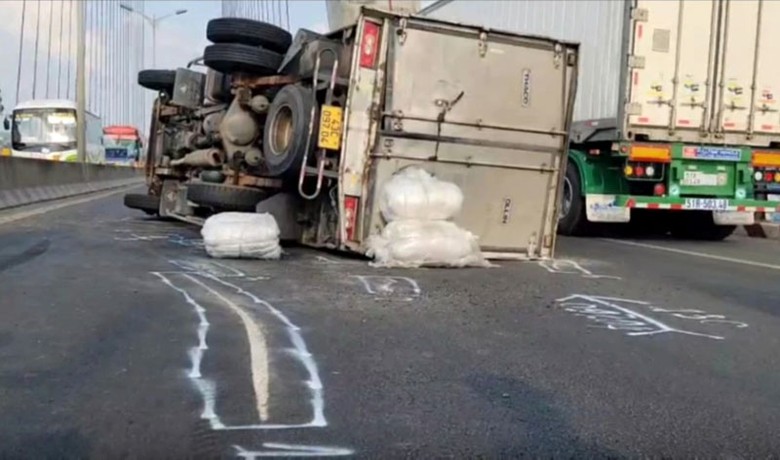 Chiếc xe tải chở nước giải kh&aacute;t bị nổ lốp rồi lật ngang giữa cầu Cần Thơ.