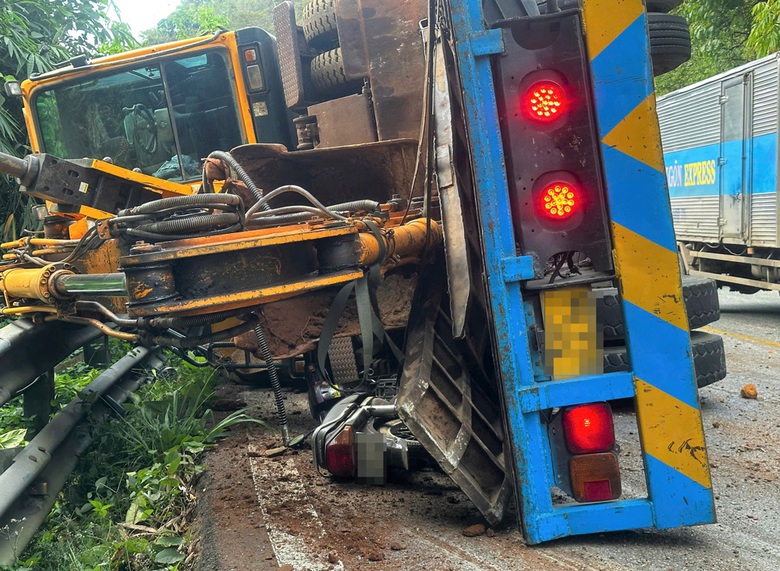 Va chạm với xe khách, xe đầu kéo chở máy xúc bị lật trên đèo Bảo Lộc- Ảnh 1. Va chạm với xe khách, xe đầu kéo chở máy xúc bị lật trên đèo Bảo Lộc- Ảnh 1.