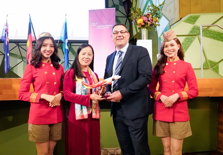 A person in a suit holding a trophy  Description automatically generated