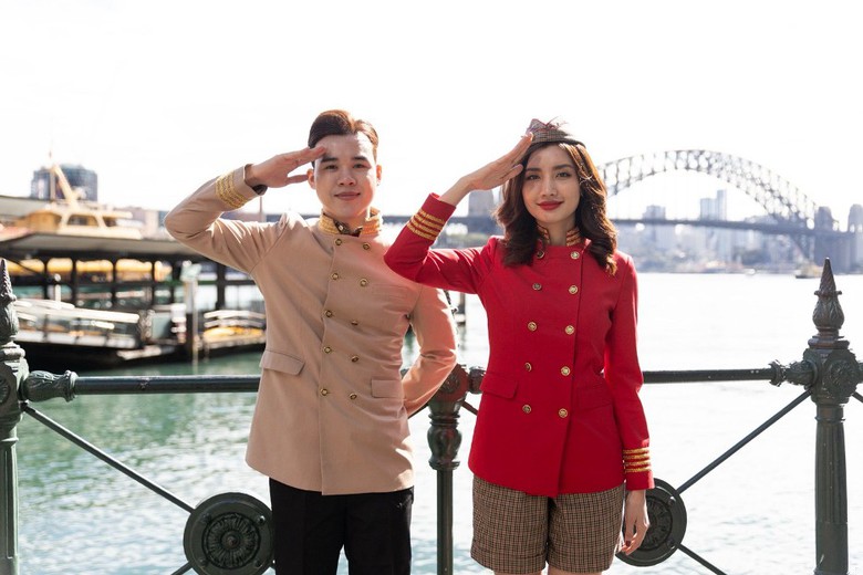 A person and person saluting in front of a bridge  Description automatically generated