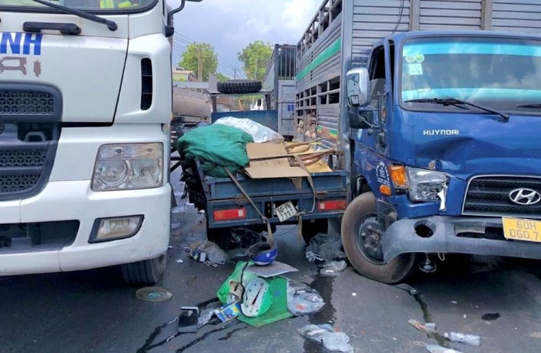 Xe ba g&aacute;c bị kẹp giữa hai xe tải, bị hư hỏng, nhiều đồ đạc rơi ra ngo&agrave;i.