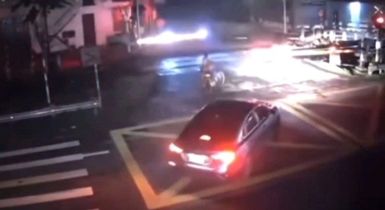 Thời điểm người phụ nữ dắt xe đạp băng qua đường ray (Ảnh cắt từ clip). Thời điểm người phụ nữ dắt xe đạp băng qua đường ray (Ảnh cắt từ clip).