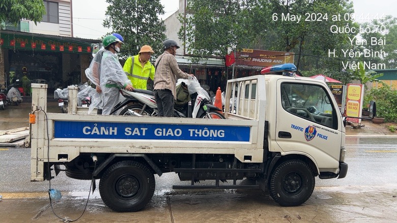 Cảnh s&aacute;t giao th&ocirc;ng Y&ecirc;n B&aacute;i đội mưa gi&uacute;p người d&acirc;n qua v&ugrave;ng ngập nước an to&agrave;n- Ảnh 1.