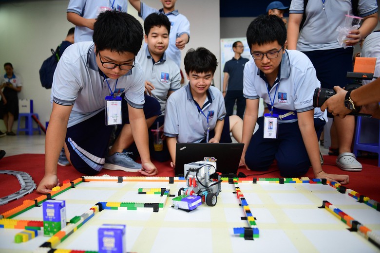 C&aacute;c bạn nhỏ h&aacute;o hứng thực hiện thử th&aacute;ch vận chuyển hộp sữa trong thời gian ngắn nhất. (Ảnh: Vi Nam)