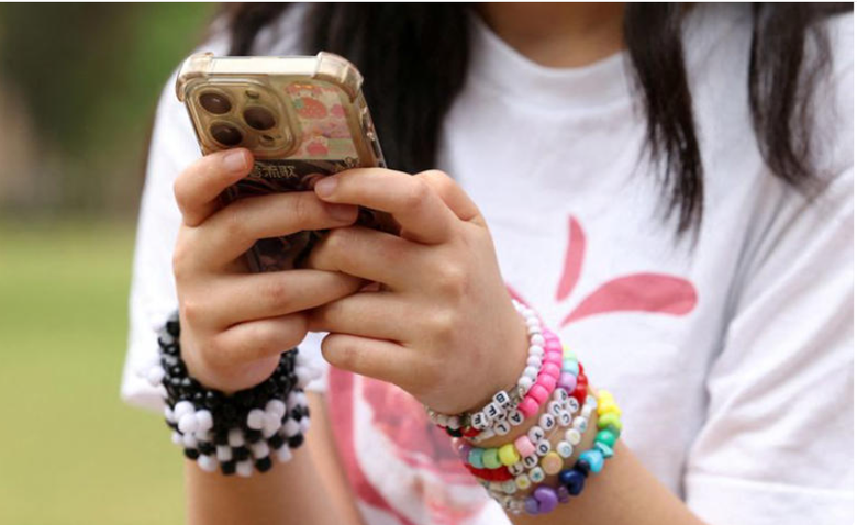 A person holding a phone  AI-generated content may be incorrect.