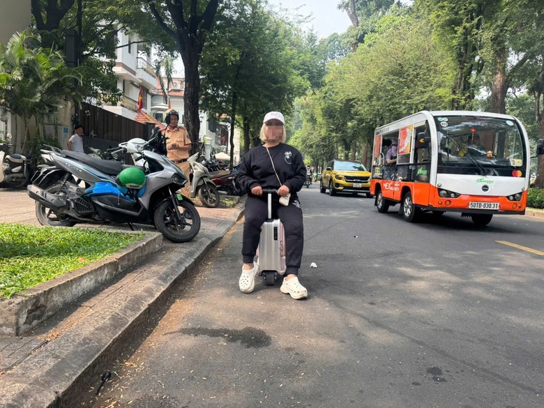 Cưỡi vali chạy tr&ecirc;n đường, người phụ nữ bị phạt 225.000 đồng- Ảnh 2.