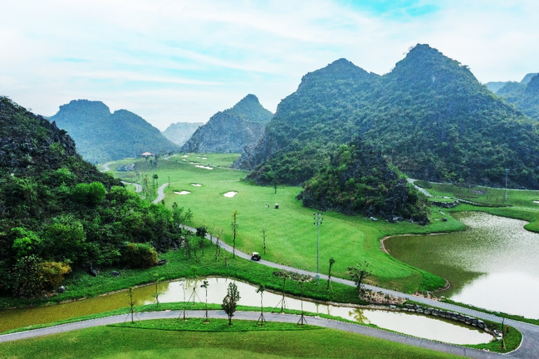 A green field with water and mountains  AI-generated content may be incorrect.