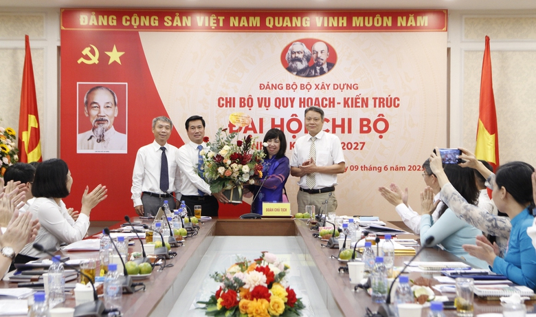 Thứ trưởng Bộ X&acirc;y dựng Nguyễn Tường Văn tặng hoa ch&uacute;c mừng v&agrave; chụp ảnh lưu niệm với Chi ủy Vụ Quy hoạch - Kiến tr&uacute;c.