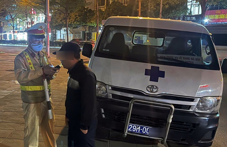 Cảnh s&aacute;t kiểm tra nồng độ cồn với t&agrave;i xế &ocirc; t&ocirc; của nh&agrave; tang lễ - Ảnh: Đ&igrave;nh Hiếu.