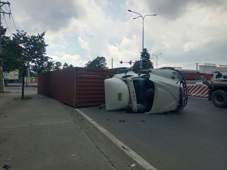 TP.HCM: Xe container lật nh&agrave;o khi &ocirc;m cua - Ảnh 1.