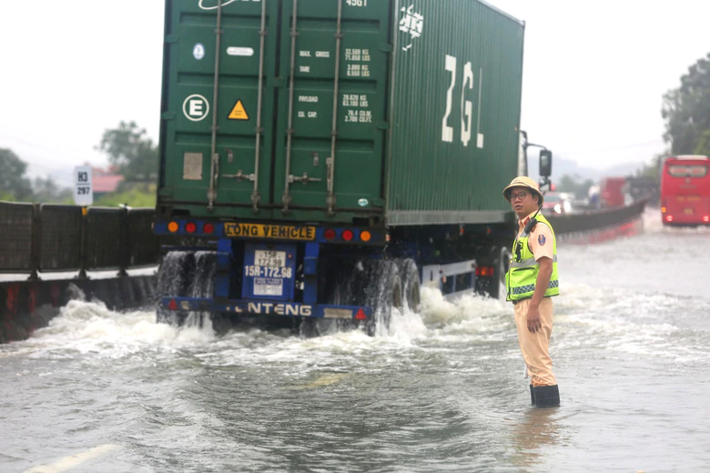 Cảnh s&aacute;t giao th&ocirc;ng Thanh H&oacute;a lội nước ph&acirc;n luồng xe khi lũ thượng nguồn tr&agrave;n về- Ảnh 2.
