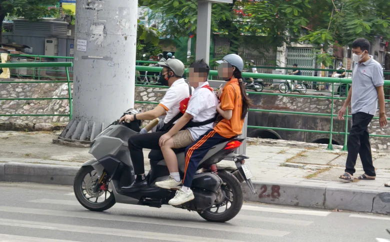 Hà Nội: Nhiều phụ huynh đi xe máy "kẹp 3", học sinh không đội mũ bảo hiểm bị CSGT xử lý - Ảnh 2.