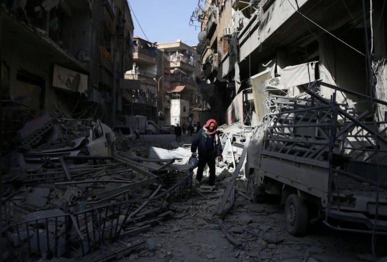Người d&acirc;n Đ&ocirc;ng Ghouta đi tr&ecirc;n đống đổ n&aacute;t sau c&aacute;c 