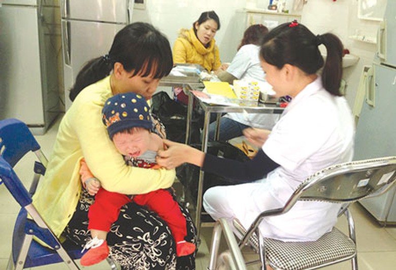 Em b&eacute; n&agrave;y đ&atilde; phải chờ gần hết buổi s&aacute;ng mới đến lượt ti&ecirc;m ph&ograve;ng vaccine sởi