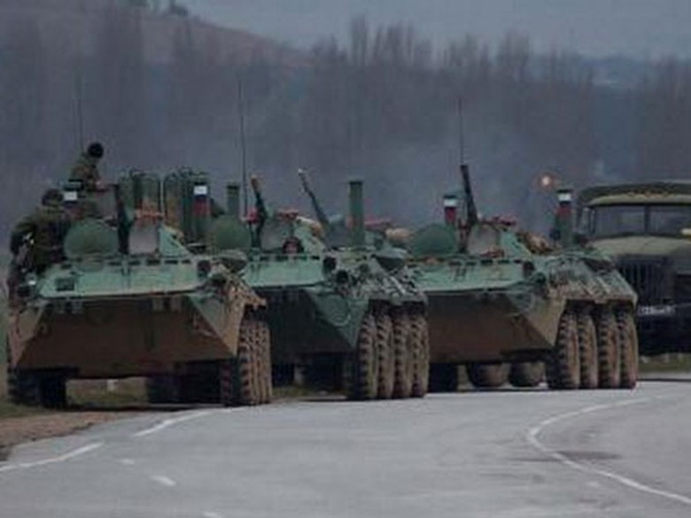 Xe bọc th&eacute;p v&agrave; một chiếc xe tải của Nga đang đậu gần một thị trấn của Ukraine. (Nguồn: AP)