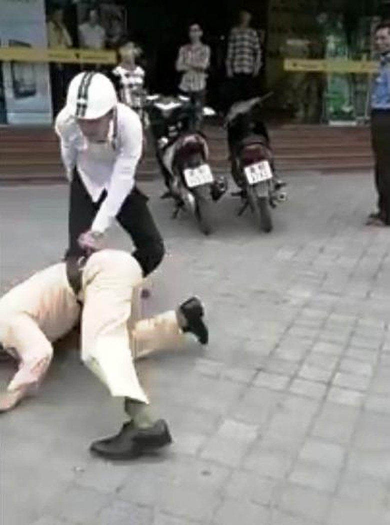 Sau c&uacute; quật người của đối tượng, Thiếu t&aacute; Hải ng&atilde; xuống đường (ảnh cắt từ Clip Youtube)