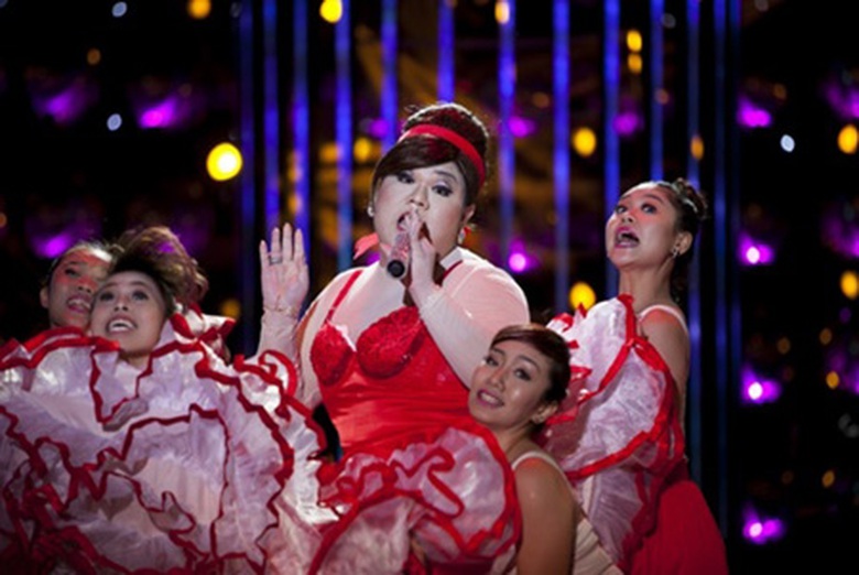 Vương Khang lạ lẫm khi thể hiện h&igrave;nh ảnh của bạn th&acirc;n - ca sĩ Yến Trang, h&aacute;t ca kh&uacute;c Taxi của Sỹ Lu&acirc;n. &lsquo;Ch&agrave;ng b&eacute;o&rsquo; mặc v&aacute;y may từ 100 m2 vải, nhảy s&ocirc;i động c&ugrave;ng vũ đo&agrave;n với điệu Flamengo nh&iacute; nhố. Đặc biệt, động t&aacute;c cuối 2 vũ c&ocirc;ng 