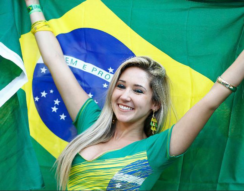 Một fan h&acirc;m mộ xinh đẹp h&acirc;n hoan cầm quốc kỳ Brazil cổ vũ tại lễ khai mạc World Cup 2014
