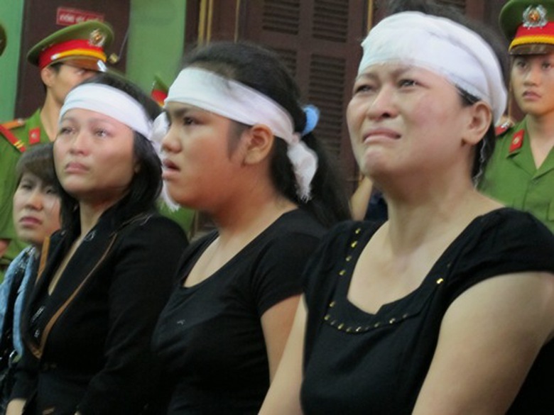 Vợ v&agrave; con g&aacute;i nạn nh&acirc;n (giữa) bức x&uacute;c tại t&ograve;a (ảnh: Người lao động)