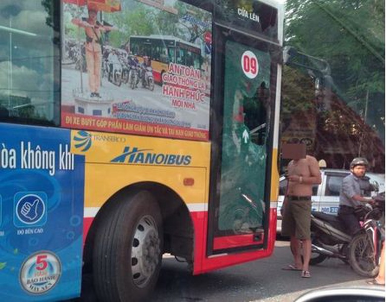 Sau khi đập vỡ cửa k&iacute;nh, người đ&agrave;n &ocirc;ng chặn đầu xe bu&yacute;t kh&ocirc;ng cho lưu th&ocirc;ng