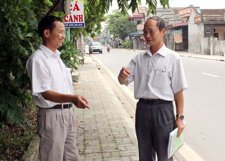 &Ocirc;ng Trần Hữu B&igrave;nh (b&ecirc;n tr&aacute;i) đ&atilde; hiến hơn 20m2 đất sổ đỏ của gia đ&igrave;nh để l&agrave;m đường