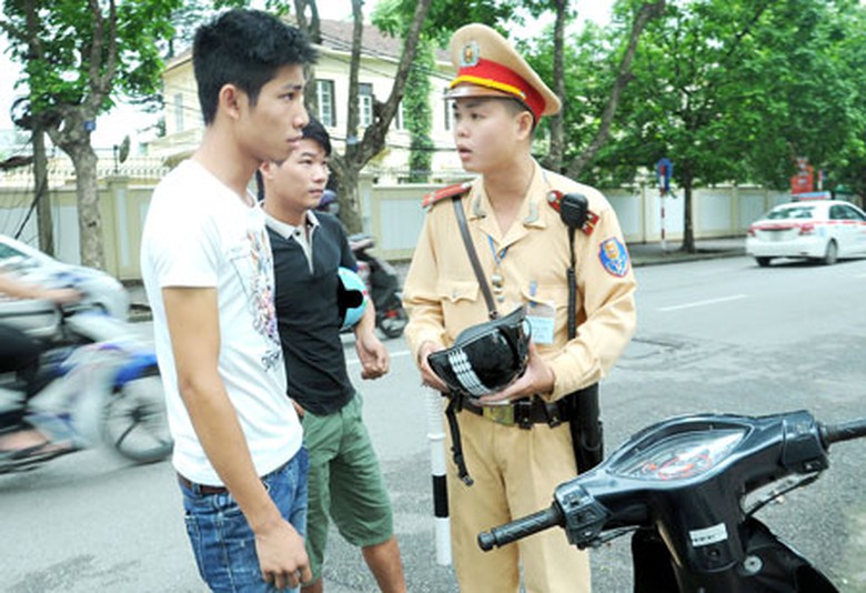 Trung &uacute;y CSGT B&ugrave;i Minh Cường tuy&ecirc;n truyền, nhắc nhở người đi xe m&aacute;y đội MBH kh&ocirc;ng đạt chuẩn (Chụp tại ng&atilde; tư Điện Bi&ecirc;n Phủ - Trần Ph&uacute;, H&agrave; Nội ng&agrave;y 1/7)