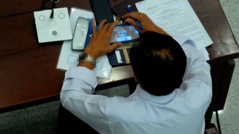 Vị đại biểu chăm ch&uacute; v&agrave;o m&agrave;n h&igrave;nh điện thoại...