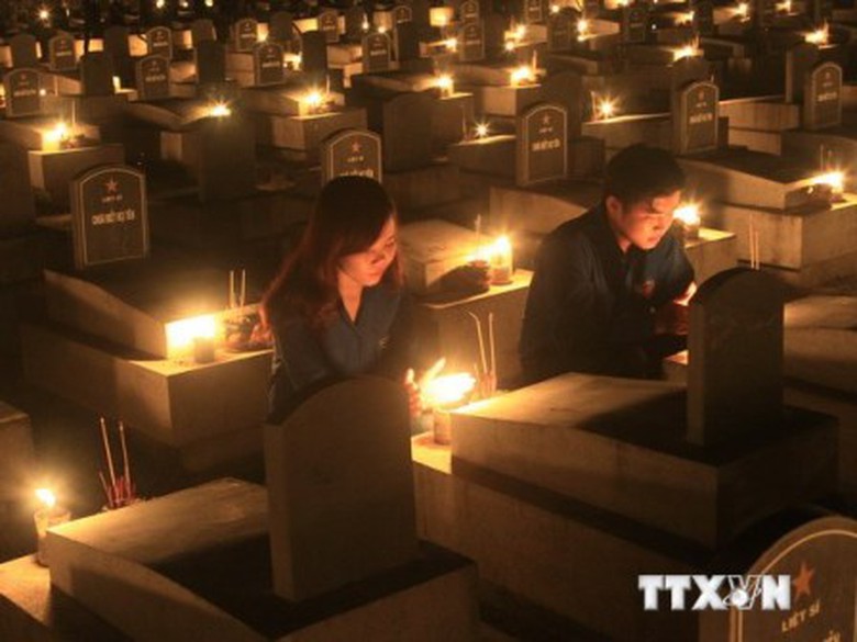 Thắp nến tri &acirc;n c&aacute;c anh h&ugrave;ng liệt sỹ. (Ảnh:TTXVN)