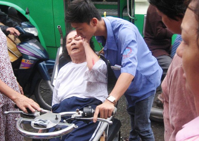 Nh&acirc;n vi&ecirc;n xe bu&yacute;t c&ugrave;ng người d&acirc;n sơ cứu cho cụ b&agrave;. 