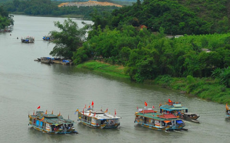 C&aacute;c thuyền rồng tham gia lễ hội rực rỡ với cờ phướn trang tr&iacute;.