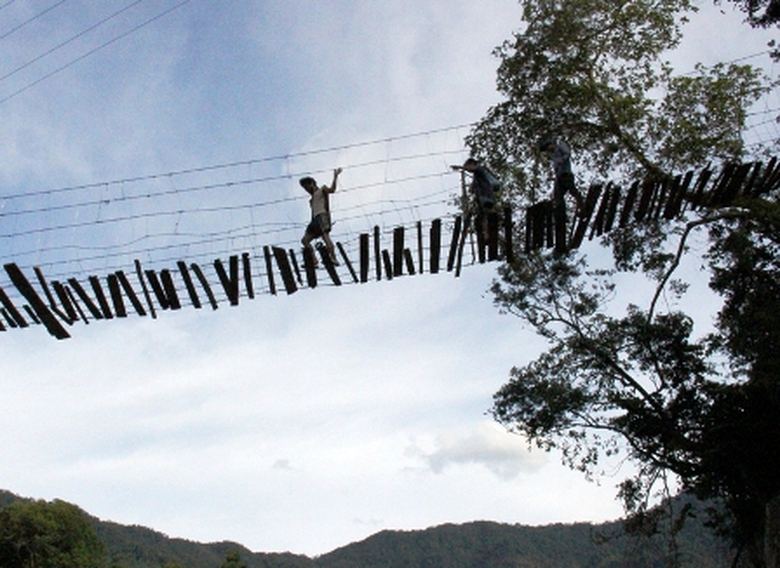 Trong khi đ&oacute;, với chiều d&agrave;i khoảng 50m, nằm ở độ cao ước 25m so với mặt s&ocirc;ng đầy đ&aacute; lởm chởm ph&iacute;a dưới. Cứ mỗi lần c&oacute; gi&oacute;, chiếc cầu lại đung đưa như thể một chiếc v&otilde;ng lớn được mắc lưng chừng trời. C&aacute;ch đ&acirc;y chưa l&acirc;u, ch&iacute;nh quyền huyện Ba Tơ đ&atilde; l&agrave;m biển b&aacute;o cấm qua lại, nhưng chỉ được v&agrave;i ng&agrave;y th&igrave; người d&acirc;n lại gỡ bỏ. Nhiều người n&oacute;i đi tr&ecirc;n cầu đ&atilde; th&agrave;nh một th&oacute;i quen v&agrave; cũng dễ d&agrave;ng hơn vượt qua sỏi đ&aacute; b&ecirc;n dưới