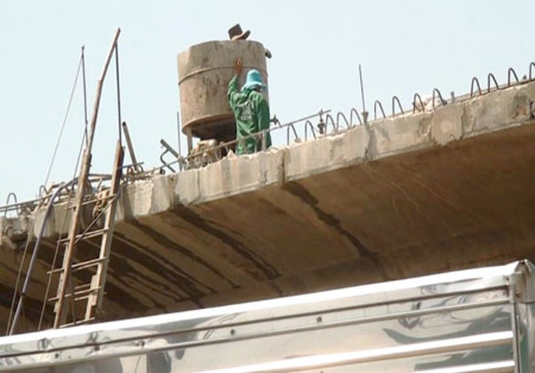 C&ocirc;ng nh&acirc;n đội mũ vải, tay trần thi c&ocirc;ng cầu T&acirc;n Vạn