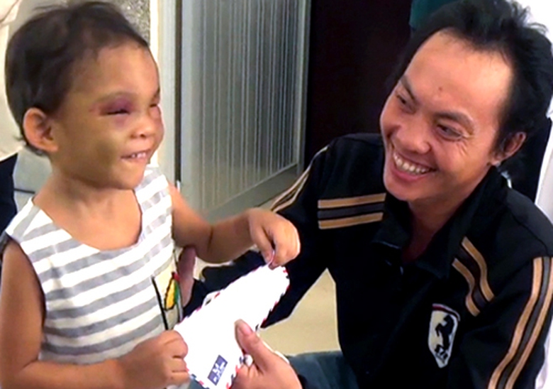 B&eacute; Ng&acirc;n cười đ&ugrave;a trong v&ograve;ng tay cha v&agrave; mọi người (Ảnh: Duy Trần/VnExpress)