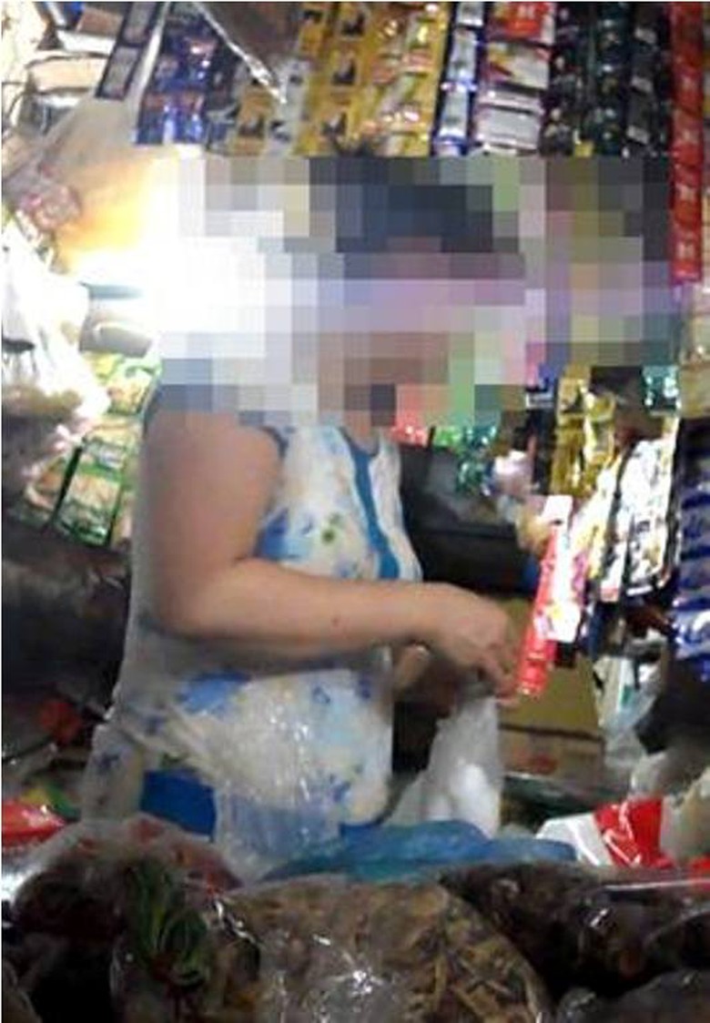 Chị H - chủ một cửa h&agrave;ng ở chợ Bưởi, Ho&agrave;ng Hoa Th&aacute;m, H&agrave; Nội đang lấy ho&aacute; chất bảo quản hoa quả.