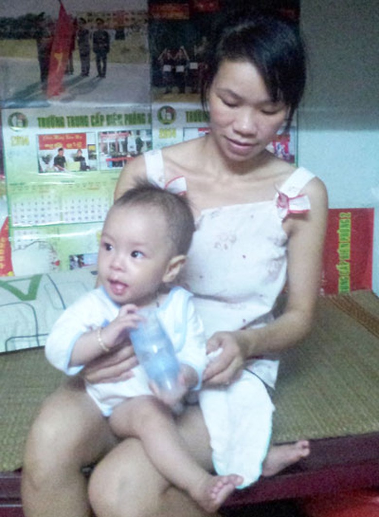 Chị Nguyễn Thị Thế, chồng mất được nửa th&aacute;ng th&igrave; sinh con, hiện chị phải bế con ra trạm g&aacute;c vừa l&agrave;m vừa tr&ocirc;ng