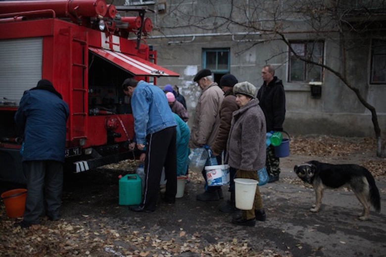 Người d&acirc;n Luhansk xếp h&agrave;ng lấy nước v&agrave;o x&ocirc; từ v&ograve;i nước của một chiếc xe cứu hoả. Theo LHQ, hơn 4.000 thiệt mạng v&agrave; h&agrave;ng trăm ngh&igrave;n người đ&atilde; phải rời bỏ nh&agrave; cửa để tr&aacute;nh c&aacute;c cuộc đụng độ giữa qu&acirc;n ch&iacute;nh phủ v&agrave; phe ly khai ở miền Đ&ocirc;ng Ukraine.
