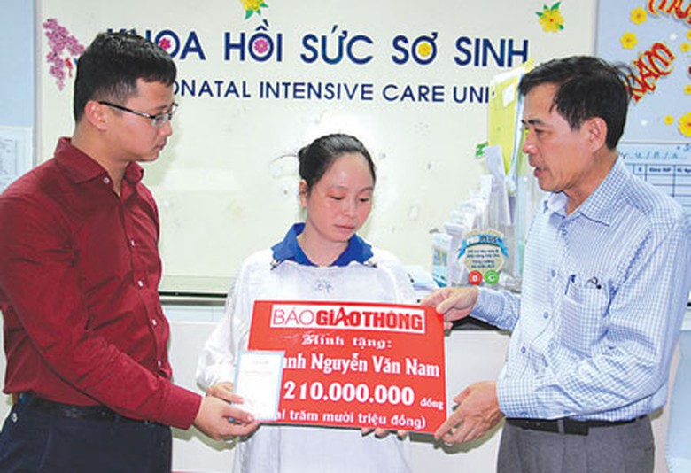 &Ocirc;ng U&ocirc;ng Việt Dũng, Ph&oacute; Ch&aacute;nh văn ph&ograve;ng Ủy ban ATGT Quốc gia v&agrave; Ph&oacute; Tổng bi&ecirc;n tập B&aacute;o Giao th&ocirc;ng Nguyễn Văn Ninh trao sổ tiết kiệm cho gia đ&igrave;nh anh Nguyễn Văn Nam