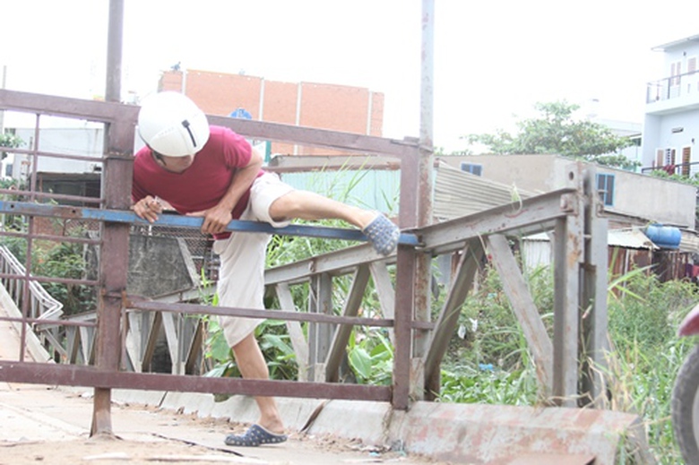 Nhiều người vẫn bất chấp nguy hiểm đi qua c&acirc;y cầu đ&atilde; sập.Nhiều người vẫn bất chấp nguy hiểm đi qua c&acirc;y cầu đ&atilde; sập.