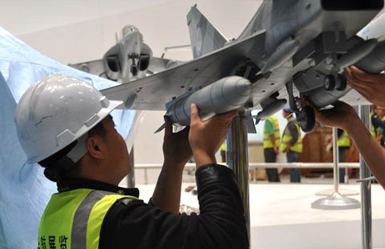 Một nh&acirc;n vi&ecirc;n kh&aacute;c lắp th&ugrave;ng nhi&ecirc;n liệu ph&iacute;a b&ecirc;n c&aacute;nh c&ograve;n lại.