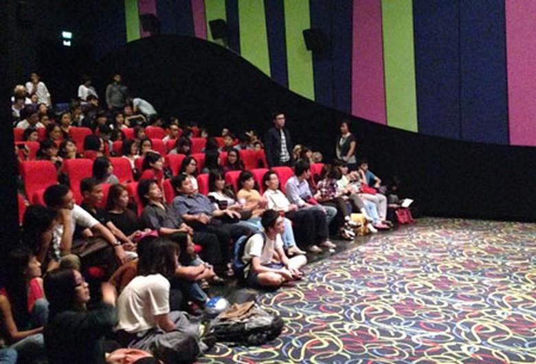 Nhiều kh&aacute;n giả ngồi bệt xuống đất xem phim