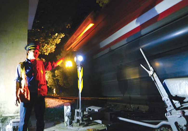 Anh H&ugrave;ng, nh&acirc;n vi&ecirc;n g&aacute;c chắn ga Lệ Sơn t&aacute;c nghiệp đ&oacute;n t&agrave;u th&ocirc;ng qua