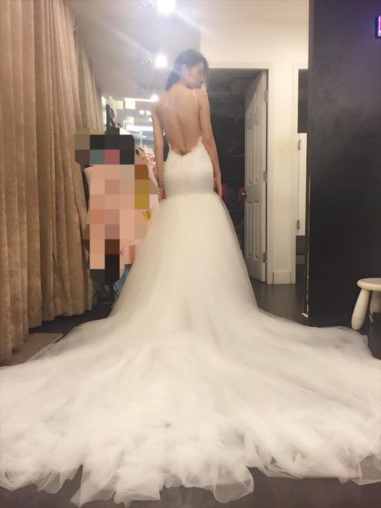 Đ&aacute;ng ch&uacute; &yacute; nhất ch&iacute;nh l&agrave; chiếc v&aacute;y cưới m&agrave;u trắng với phần đu&ocirc;i d&agrave;i v&agrave; khăn voan che đầu rất cầu kỳ. bộ v&aacute;y cũng cho thấy c&ocirc; sở hữu một h&igrave;nh xăm rất lớn ở thắt lưng.