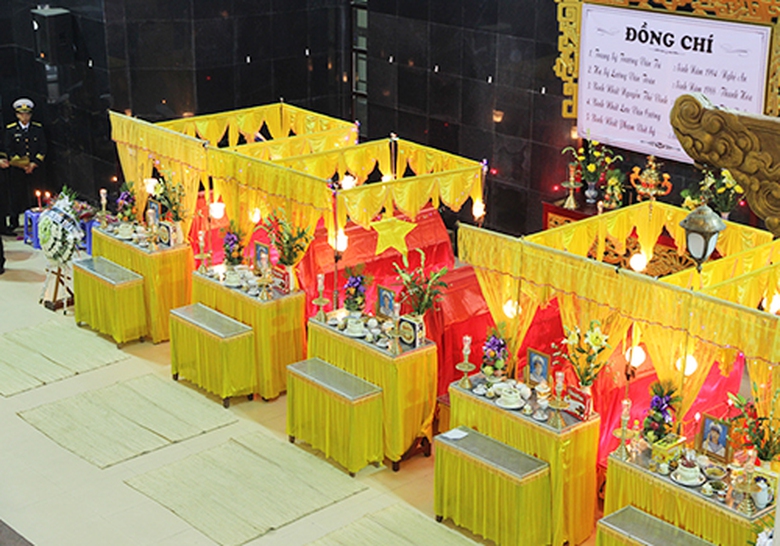 5 linh cữu của c&aacute;c chiến sĩ tử nạn tr&ecirc;n đường l&agrave;m nhiệm vụ được đặt cạnh nhau, phủ l&ecirc;n tr&ecirc;n l&agrave; l&aacute; cờ Tổ quốc